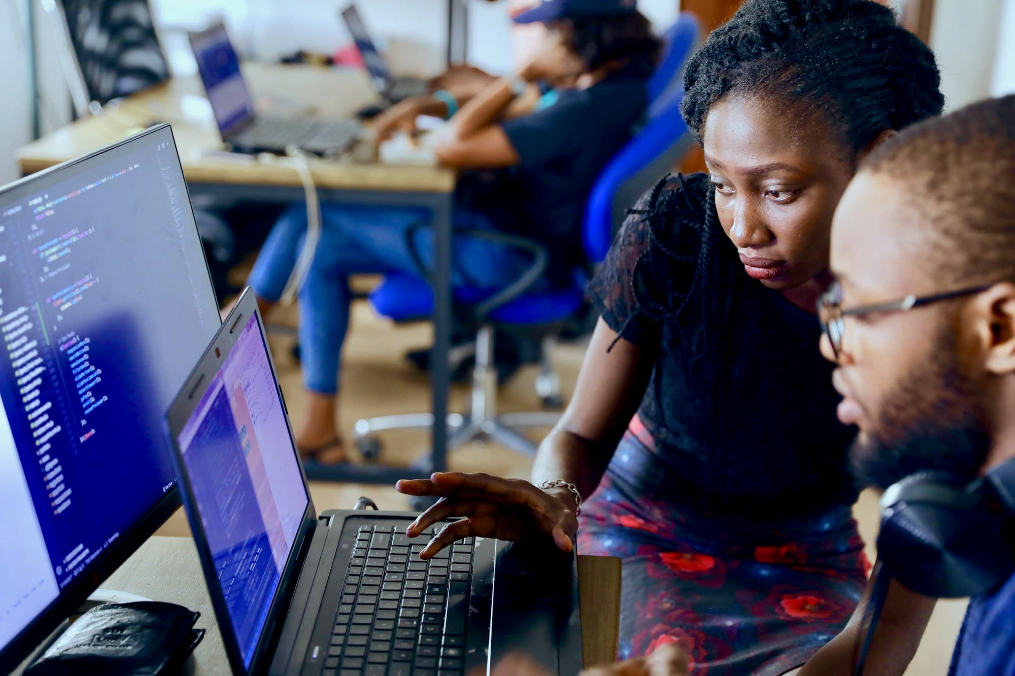 Deux développeurs en pair programming, concentrés devant leurs écrans.